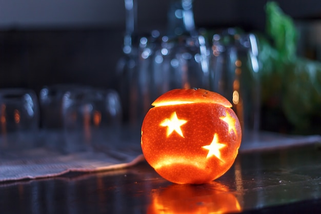 Orange de vacances sur une table sombre avec de la lumière.