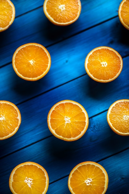 Orange. Vue de dessus des oranges fraîches coupées sur une table bleue.