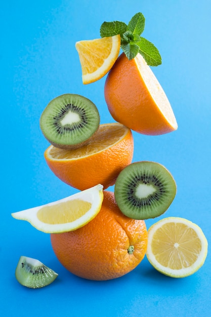 Oranges, citron et kiwi pyramide empilée sur bleu