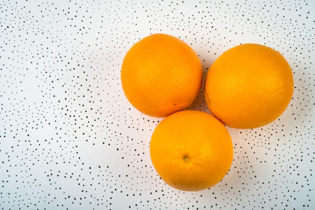 Oranges entières sur fond pointillé