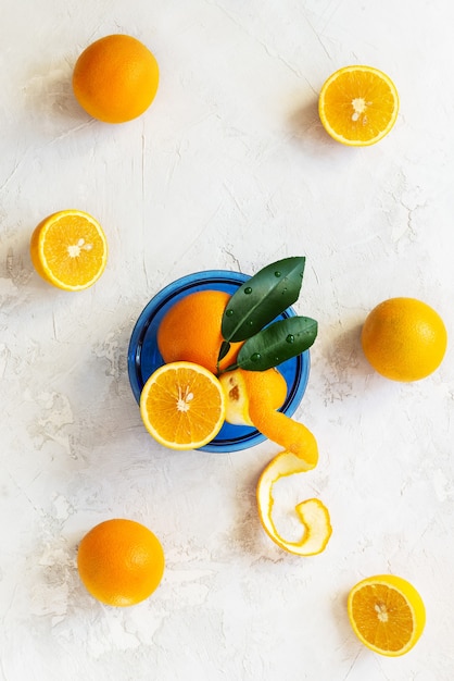 Oranges avec des feuilles dans une assiette en verre bleu