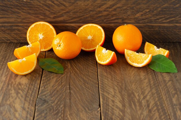 Oranges fraîches avec avant-toit vert sur fond de bois rustique avec copie cpace.