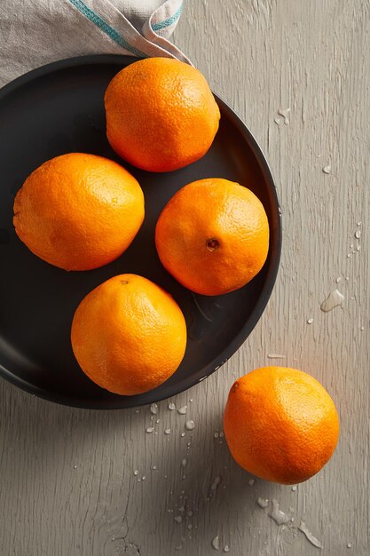 Oranges fraîches dans une assiette sur une table en bois