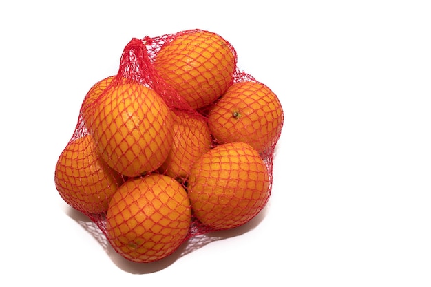 Oranges fraîches dans un sac en filet en plastique isolé sur fond blanc