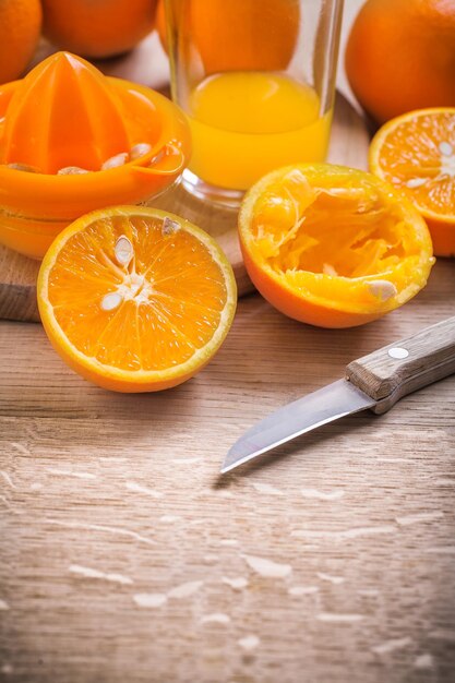 Oranges juicer couteau verre de jus sur planche de bois