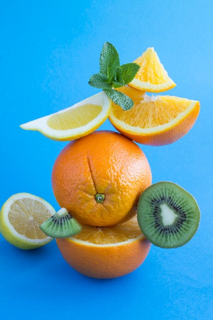 Oranges et kiwi pyramide empilée sur le fond bleu. Emplacement vertical.