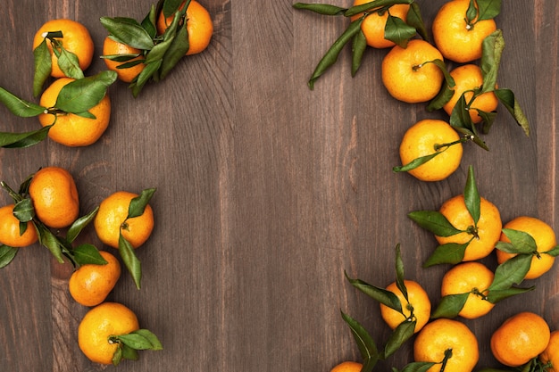 Oranges mandarines avec feuilles sur bois rustique