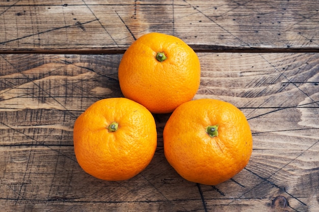 Oranges mandarines ou mandarines clémentines, agrumes sur table en bois rustique