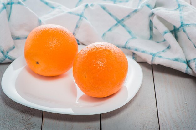 Oranges mûres fraîches sur une lumière naturelle de table