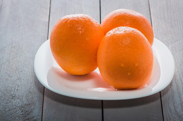 Oranges mûres fraîches sur une lumière naturelle de table