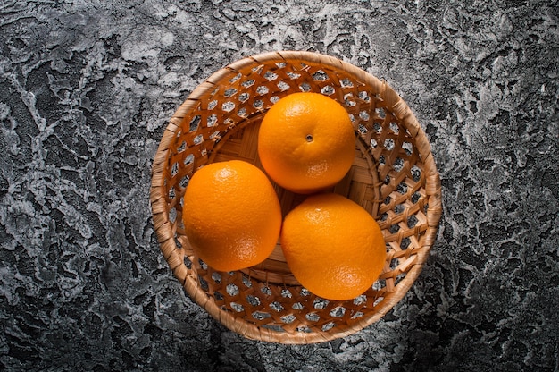 Oranges mûres fraîches sur une lumière naturelle de tableOranges dans un panier