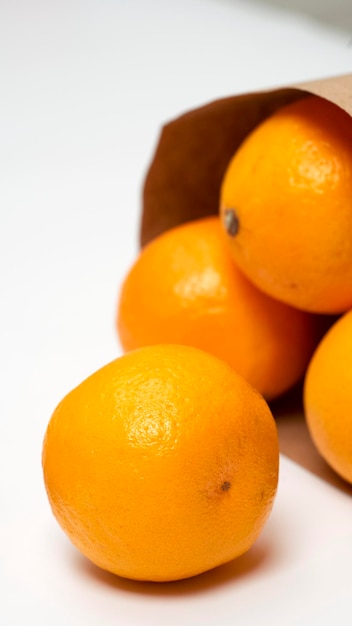 Oranges oranges mûres lumineuses dans le paquet sur un fond blanc. Vue d'en-haut.