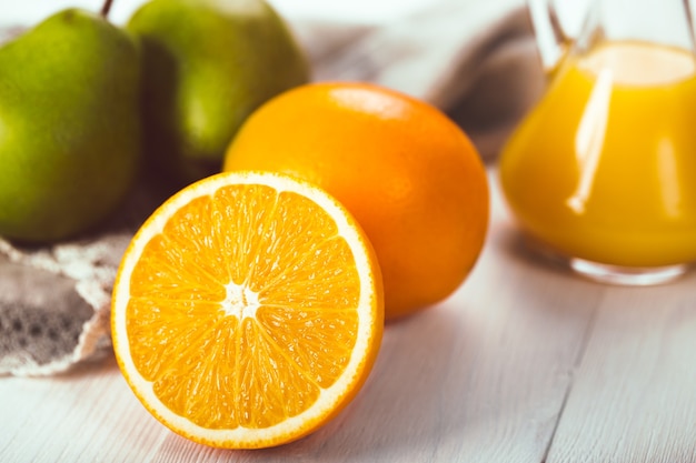 Oranges et poires sur une table en bois blanc