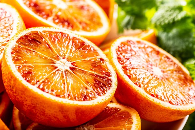 Photo des oranges siciliennes en tranches avec de la mélisse fraîche de près.