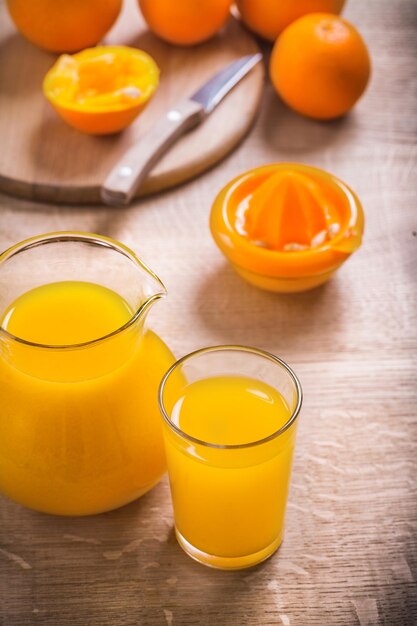 Oranges squeezer couteau verre de jus sur planche de bois