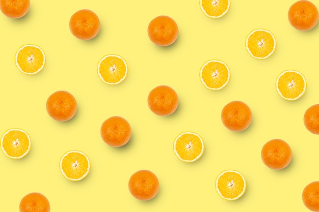 Oranges et tranches d'oranges isolées sur fond jaune