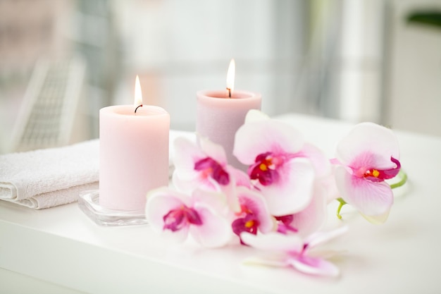 Orchidées et bougies aromatiques brûlantes sur le salon spa