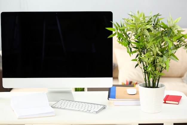 Ordinateur argent vide à table de travail avec canapé