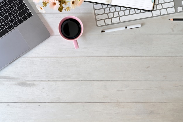 Ordinateur de bureau avec clavier, tasse à café, bloc-notes et fournitures de bureau