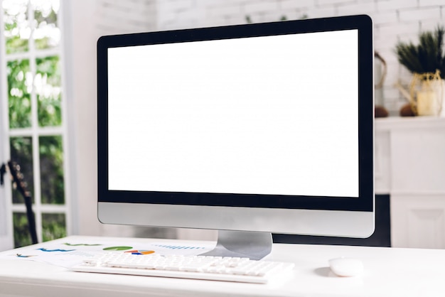 Ordinateur de bureau créatif avec des écrans blancs blancs sur la table dans un loft de travail blanc minimal moderne