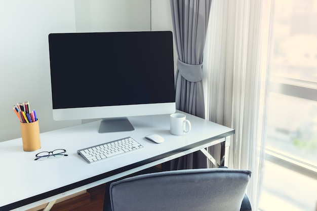 Ordinateur de bureau vierge avec clavier, agenda et autres accessoires sur tableau blanc