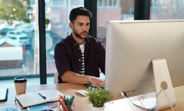 Ordinateur d'entreprise et homme travaillant à un bureau en ligne pour la recherche ou le travail créatif Homme entrepreneur sur le lieu de travail avec concentration et connexion Internet pour un projet de concepteur ou la lecture d'e-mails