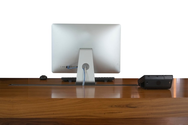 Un ordinateur personnel de bureau en aluminium moderne avec téléphone clavier souris sans fil sur la table en bois fond blanc isolé