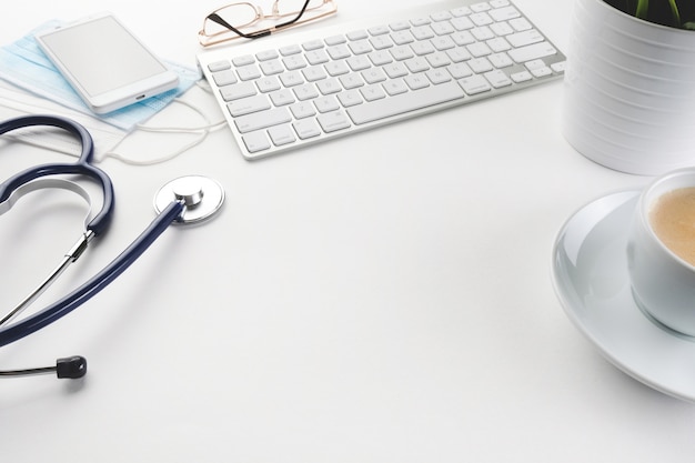 Ordinateur, phonendoscope et café sur un tableau blanc. Bureau du médecin.