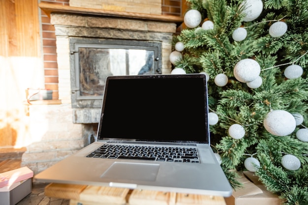 ordinateur portable et arbre de noël dans une vieille maison en bois