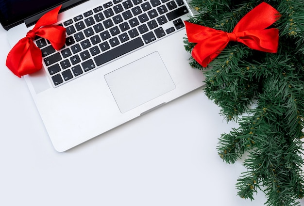 Ordinateur portable avec des arcs rouges et une branche de sapin