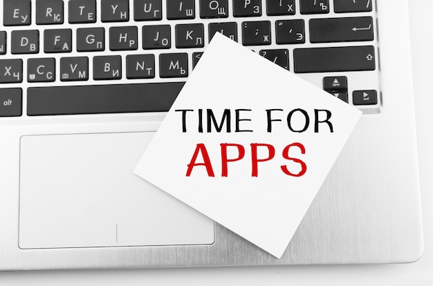 Ordinateur portable avec des bâtons de mémo sur le clavier avec du texte TIME FOR APPS dessus.