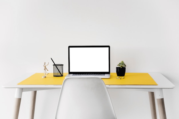 Ordinateur portable sur le bureau contre le mur blanc