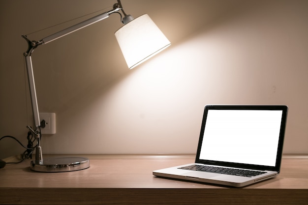 Ordinateur portable sur un bureau avec lampe