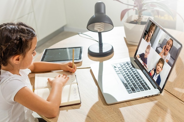 ordinateur portable avec des camarades de classe d'enfants de vidéoconférence se tient sur la table.