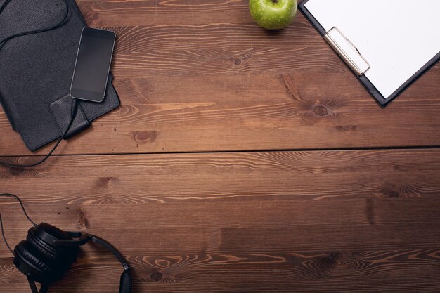 Photo un ordinateur portable, un carnet et une pomme sur une table en bois.