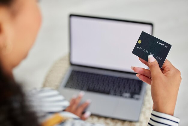 Ordinateur portable de carte de crédit et femme faisant des achats en ligne bancaires et paiement en ligne depuis sa maison Commerce de détail en ligne et personne lisant des informations sur une carte de débit pour payer un magasin sur le web avec la technologie