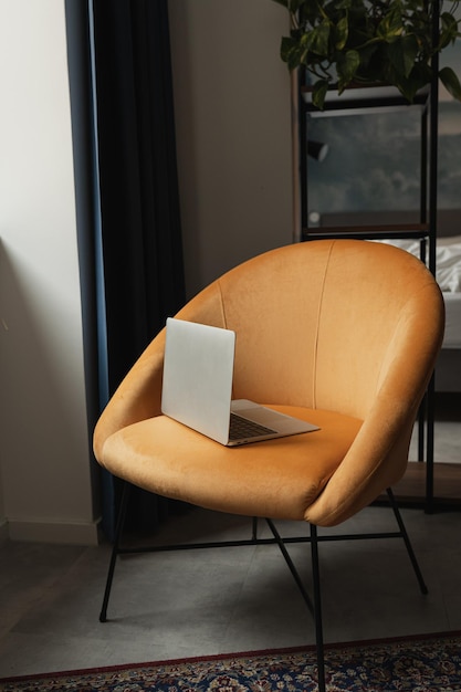 Ordinateur portable sur chaise longue orange confortable Design d'intérieur