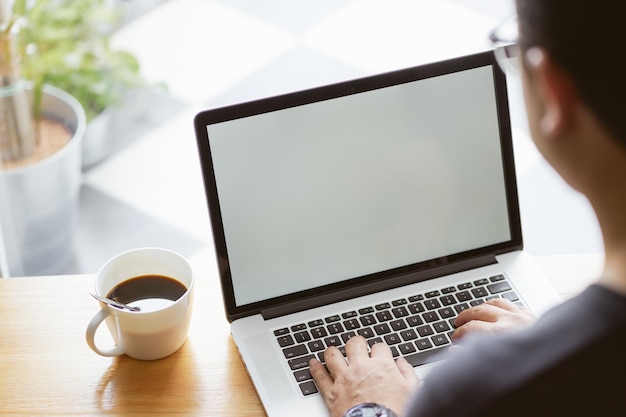 Ordinateur portable dans la main de l'homme d'affaires avec du café