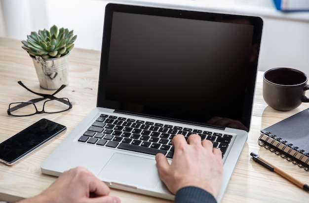 Ordinateur portable avec écran blanc noir sur un bureau en bois