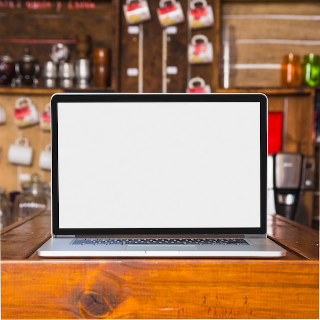 Photo ordinateur portable avec un écran blanc sur la table dans le café