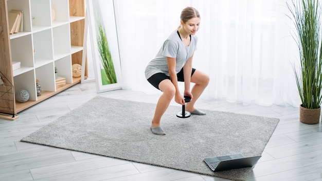 Ordinateur portable d'exercice de fille de gym en ligne de fitness à domicile pour enfants