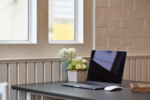 Ordinateur portable avec des fournitures de bureau et des gadgets sur une table en bois