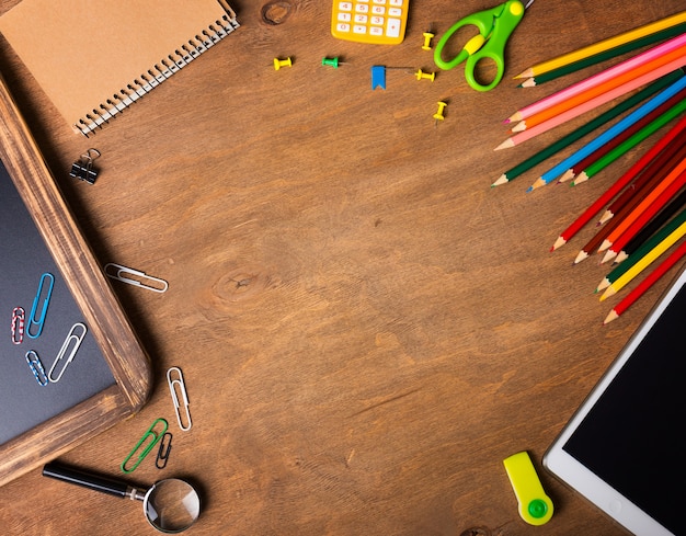 Ordinateur portable avec des fournitures scolaires sur un fond en bois