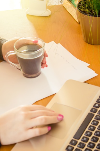 Ordinateur portable gros plan d&#39;un clavier et d&#39;une tasse de café chaud le matin. Mise au point sélective.