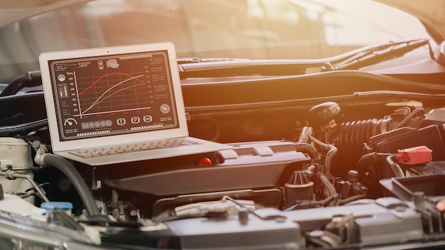 Photo ordinateur portable en gros plan avec réglage de la vitesse de l'ecu du moteur de voiture de course avec logiciel moderne affichant le couple et la puissance à l'écran