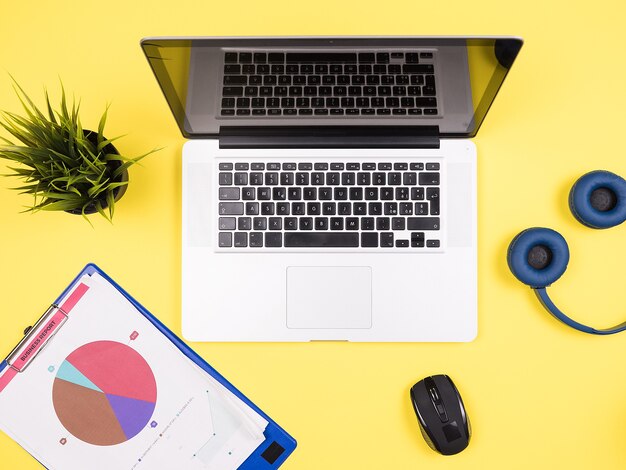 Ordinateur portable d'homme d'affaires sur le concep de vue de dessus de bureau jaune, écouteurs, pot d'herbe, lunettes de soleil