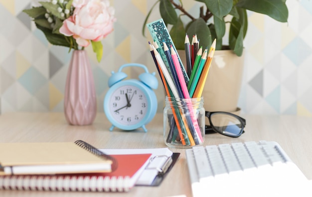 Ordinateur portable avec lampe électrique, crayons et réveil sur fond de mur de briques