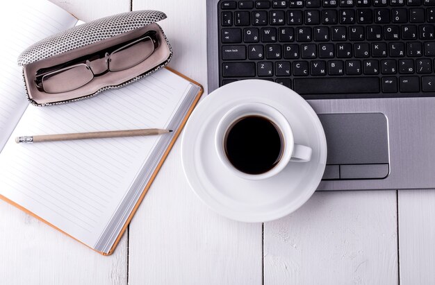 Ordinateur portable, ordinateur portable avec une tasse de café et un crayon allongé sur une table en bois. Vue de dessus