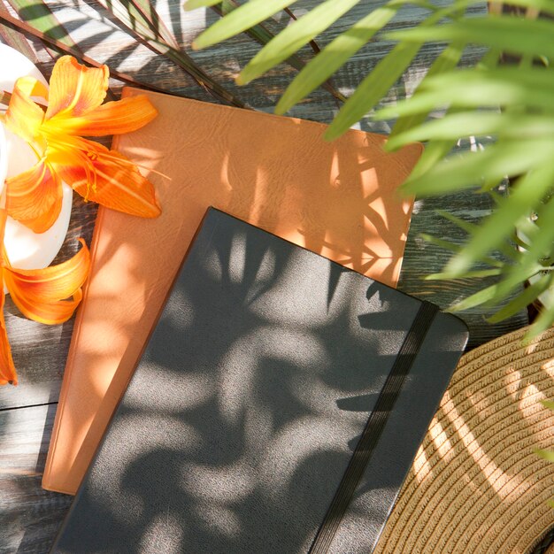 Ordinateur portable à plat avec des fleurs de lys et des ombres de palmiers, en plein air