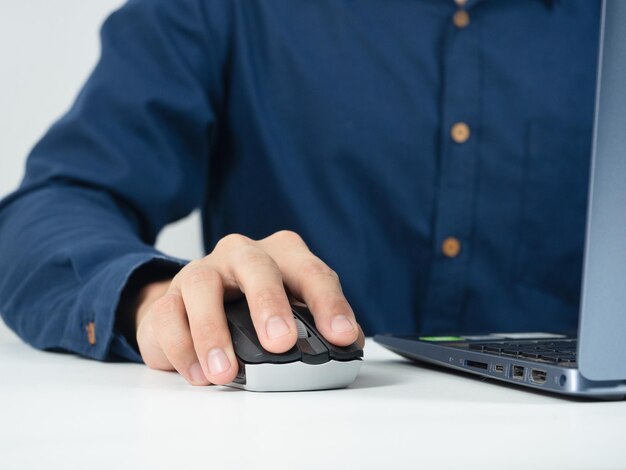 Ordinateur portable de souris de capture de main d'homme de plan rapproché travaillant sur la table